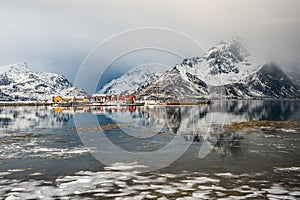 Scenery with reflected cottages and clouds in Lofoten, Norway