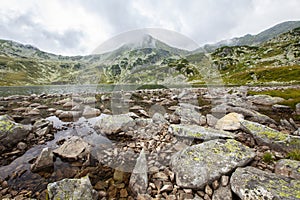 Scenery in the Romanian Alps, with stormy cloudscape and granite slabs