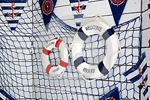 Scenery sea, marine theme. White wooden board with lifebuoys, fishing net and flags