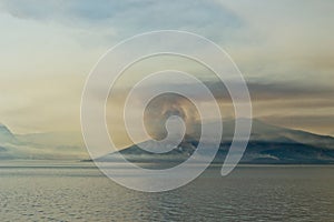 Scenery of smoke coming out of the mountain at the ocean