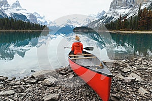 Scenery of Spirit Island with female traveler on kayak by the Maligne Lake in the morning at Jasper national park