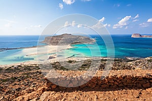 Scenery of sunny summer day with sand beach, turquoise sea and mountains. Blue horizon line. Place for tourists rest Balos lagoon.