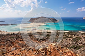 Scenery of sunny summer day with sand beach, turquoise sea and mountains. Blue horizon line. Place for tourists rest Balos lagoon.