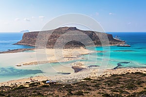 Scenery of sunny summer day with sand beach, turquoise sea and mountains. Blue horizon line. Place for tourists rest Balos lagoon.