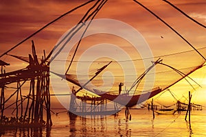 Scenery of sunrise over lake with thai traditional fishing trap at Pakpra