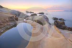 Scenery of sunrise by rocky coast in northern Taiwan
