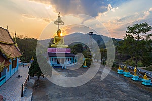 Scenery sunset behind the golden buddha in Chiang Rai