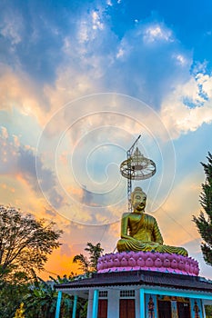 Scenery sunset behind the golden buddha in Chiang Rai