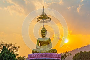 Scenery sunset behind the golden buddha in Chiang Rai