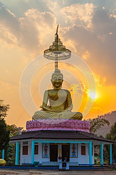 Scenery sunset behind the golden buddha in Chiang Rai