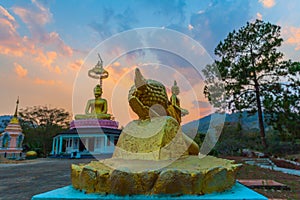 Scenery sunset behind the golden buddha in Chiang Rai