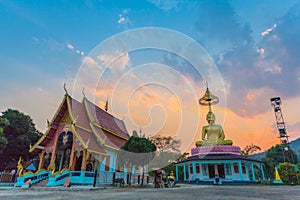 Scenery sunset behind the golden buddha in Chiang Rai