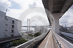 Scenery of a train traveling on the elevated rail of Yurikamome Line in Odaiba. Road under the bridge