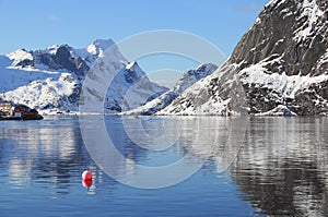 Scenery winter landscape with red buoy in the fishing village of Reine, Lofoten, Norway, above the arctic circle