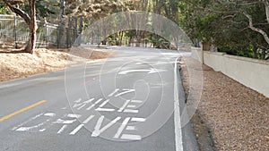 Scenic 17-mile drive, Monterey, California coast. Sign on asphalt, road marking.