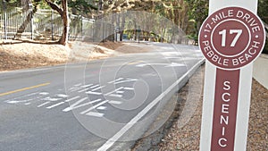 Scenic 17-mile drive, Monterey, California coast. Sign on asphalt, road marking.