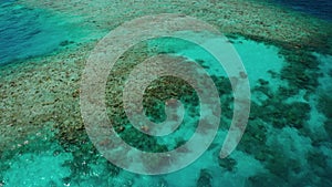 Scenic aerial video from a drone over a tropical coral reef in the ocean in the Maldives