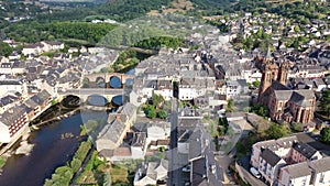 Scenic aerial view of French commune of Espalion on banks of Lot river with medieval Parish Church on summer day