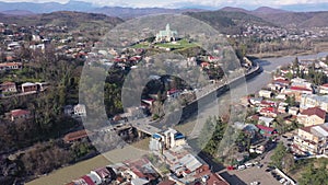 Scenic aerial view of Kutaisi cityscape on banks of Rioni River in spring overlooking medieval Bagrati Cathedral