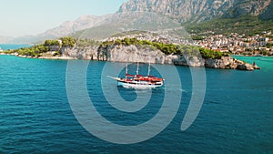 Scenic aerial view of Makarska town with a large ship near the waterfront. Summer seascape in Croatia. Popular tourist