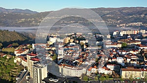 Scenic aerial view of Portuguese city of Vila Real located on mountain plateau covered by light misty haze on sunny