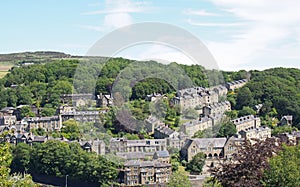 A scenic aerial view of the town of hebden bridge in west yorkshire with hillside streets of stone houses and roads between trees