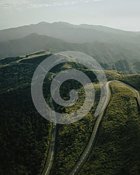 Scenic aerial view of a winding mountain road surrounded by lush green vegetation, Datun Mountain