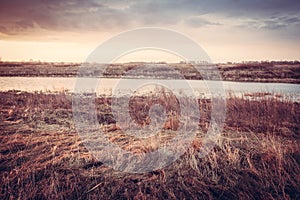 Scenic autumn landscape during dawn at river bank in rural field