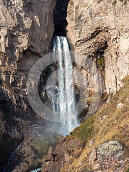 Scenic autumn landscape with vertical big Sultan waterfall at mountain top in sunshine in the Jila-Su tract. Kabardino-Balkaria.