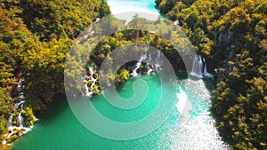 Scenic autumn landscape of waterfall in colourful forest. Aerial view of Plitvice Lakes National Park. Famous travel