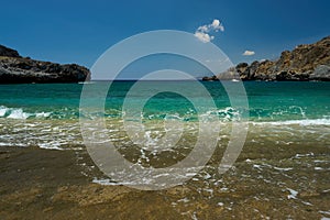 Scenic beach with clear, pristine water and rolling waves.