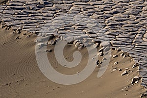Scenic beachscape featuring an impressive wave-like formation made of sand and rocks