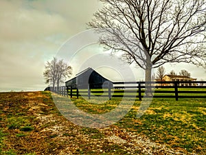 Scenic black barn and fence in Shelbyville, Kentucky photo
