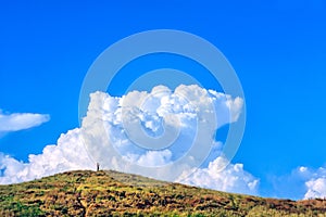 Scenic blue sky summer landscape with cumulus clouds and boy standing with camera on hill. Anapa, Caucasus. Russia