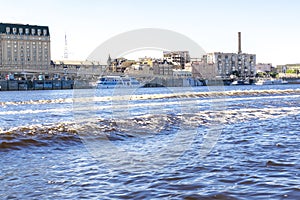 Scenic bright travel cityscape of river Dnipro in Kiev with blue water, bridge, pleasure ships, residential buildings in