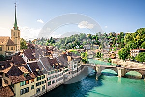 Scenic cityscape of Bern at sunset with untertorbrucke bridge over Aare river and Nydegg church view with dramatic light in Bern