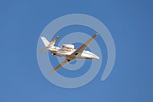 Scenic close bottom view modern luxury expensive white private jet plane dispatching from airport isolated on blue clear