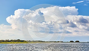 Scenic cloudscape over land and water on a sunny day