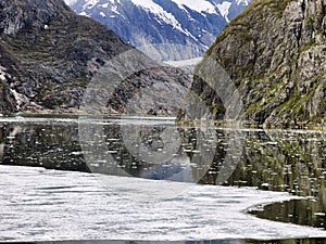 Scenic coastal landscape with steep glacially polished cliffs and floating ice at Tracy Arm Fjord photo