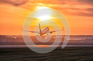 Scenic dawn with a fog at the airport. Takeoff of a passenger airplane photo