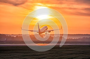 Scenic dawn with a fog at the airport. Takeoff of a passenger airplane