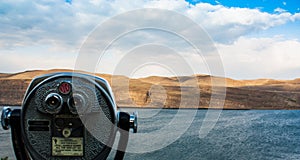 Scenic desert river view showing coin-op binoculars