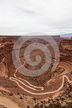 Scenic Dirt Road surrounded by Red Rock Mountains in Desert Canyon.