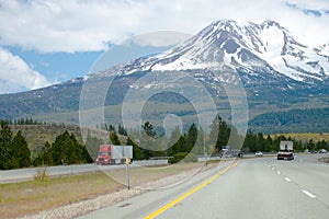 Scenic divided highway with semi trucks and snow mountain