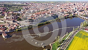 Scenic drone view of ancient Spanish city of Zamora on banks of Duero river overlooking medieval stone bridge on sunny