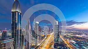 Scenic Dubai downtown architecture day to night timelapse. Top view over Sheikh Zayed road with illuminated skyscrapers