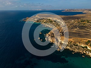 Scenic golden rocky cliffs in Malta aerial near famous Golden Bay Beach