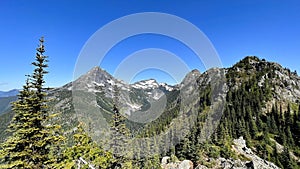 Scenic green mountain range against the backdrop of a blue sky. Goat Ridge Hike, Chilliwack, Canada.