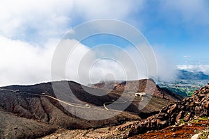 Scenic high angle view on Aso town, walk way from crater of active volcano Aso, mountains and abandoned old cable car building