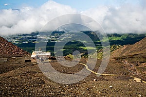 Scenic high angle view on Aso town, walk way from crater of active volcano Aso, mountains and abandoned old cable car building